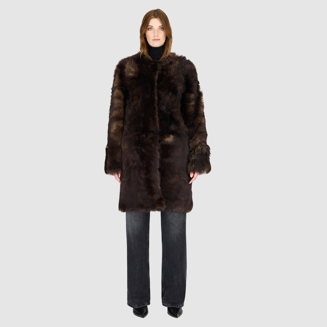 The ALLORA Jacket is a luxury reversible shearling teddy crafted in wolf Toscana for a rich and modern finish. Designed as a collarless oversized silhouette, it effortlessly flips from plush wool-out shearling to a sleek nappa skin-out jacket, offering two looks in one. With its generous fit through the shoulders, arms, and torso, ALLORA balances comfort and style. Functional slash side pockets on both sides and a front snap closure complete this elevated women’s reversible shearling jacket.