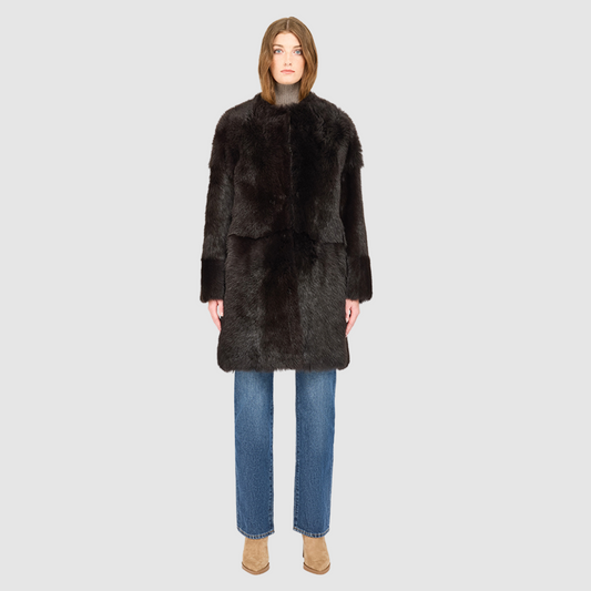 The ALLORA Jacket is a luxury reversible shearling teddy crafted in chocolate silky Toscana for a rich and modern finish. Designed as a collarless oversized silhouette, it effortlessly flips from plush wool-out shearling to a sleek nappa skin-out jacket, offering two looks in one. With its generous fit through the shoulders, arms, and torso, ALLORA balances comfort and style. Functional slash side pockets on both sides and a front snap closure complete this elevated women’s reversible shearling jacket.
