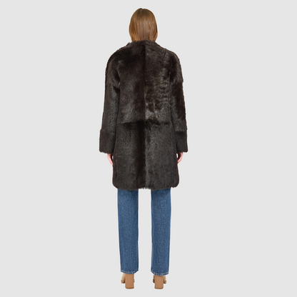 The ALLORA Jacket is a luxury reversible shearling teddy crafted in chocolate silky Toscana for a rich and modern finish. Designed as a collarless oversized silhouette, it effortlessly flips from plush wool-out shearling to a sleek nappa skin-out jacket, offering two looks in one. With its generous fit through the shoulders, arms, and torso, ALLORA balances comfort and style. Functional slash side pockets on both sides and a front snap closure complete this elevated women’s reversible shearling jacket.
