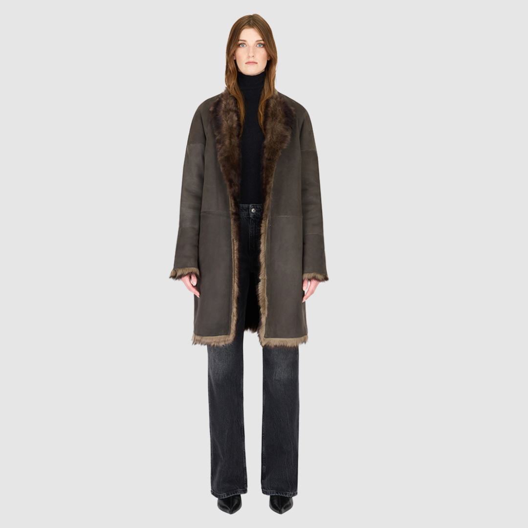 The ALLORA Jacket is a luxury reversible shearling teddy crafted in wolf Toscana for a rich and modern finish. Designed as a collarless oversized silhouette, it effortlessly flips from plush wool-out shearling to a sleek nappa skin-out jacket, offering two looks in one. With its generous fit through the shoulders, arms, and torso, ALLORA balances comfort and style. Functional slash side pockets on both sides and a front snap closure complete this elevated women’s reversible shearling jacket.