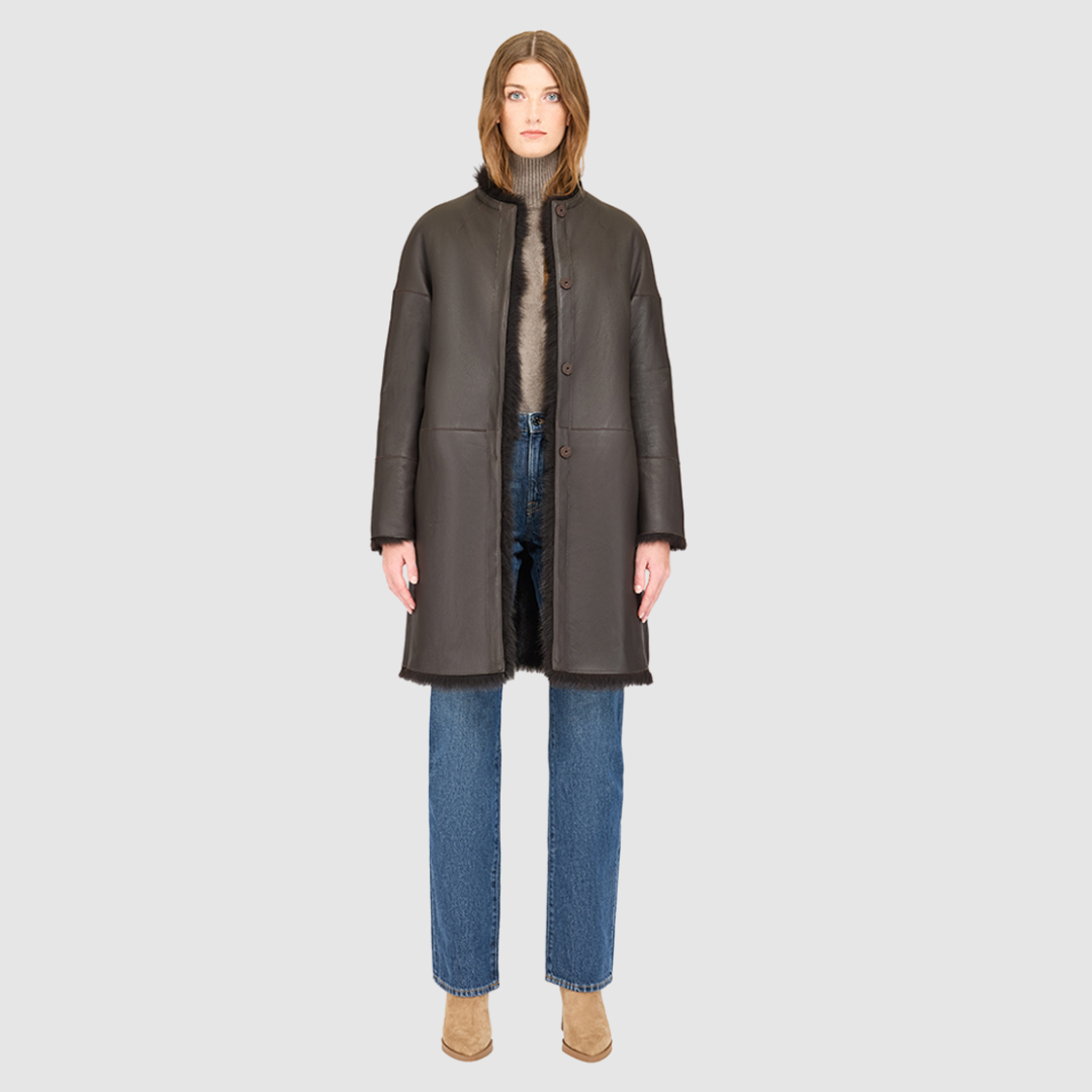 The ALLORA Jacket is a luxury reversible shearling teddy crafted in chocolate silky Toscana for a rich and modern finish. Designed as a collarless oversized silhouette, it effortlessly flips from plush wool-out shearling to a sleek nappa skin-out jacket, offering two looks in one. With its generous fit through the shoulders, arms, and torso, ALLORA balances comfort and style. Functional slash side pockets on both sides and a front snap closure complete this elevated women’s reversible shearling jacket.