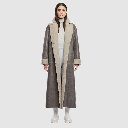 The DANIELLE Duster is a statement in heritage-inspired luxury and modern versatility. Crafted in Macassar nappa leather and plush curly wool shearling, this reversible oversized coat transitions effortlessly from sleek leather to cozy teddy texture. Its elongated silhouette is enhanced with a slight drop shoulder, back vent, and double-breasted button closure, creating timeless elegance with functional edge. Practical single welt pockets on the nappa side and slash pockets on the wool side