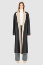 The DANIELLE Duster is a statement in heritage-inspired luxury and modern versatility. Crafted in black beige nappa and plush iron wool shearling, this reversible oversized coat transitions effortlessly from sleek leather to cozy teddy texture. Its elongated silhouette is enhanced with a slight drop shoulder, back vent, and double-breasted button closure, creating timeless elegance with functional edge. Practical single welt pockets on the suede side and slash pockets on the wool side