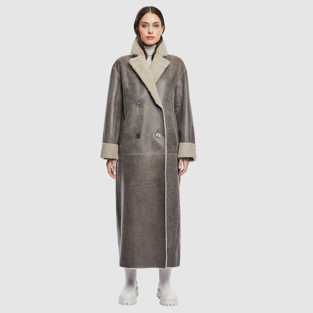 The DANIELLE Duster is a statement in heritage-inspired luxury and modern versatility. Crafted in Macassar nappa leather and plush curly wool shearling, this reversible oversized coat transitions effortlessly from sleek leather to cozy teddy texture. Its elongated silhouette is enhanced with a slight drop shoulder, back vent, and double-breasted button closure, creating timeless elegance with functional edge. Practical single welt pockets on the nappa side and slash pockets on the wool side