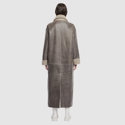 The DANIELLE Duster is a statement in heritage-inspired luxury and modern versatility. Crafted in Macassar nappa leather and plush curly wool shearling, this reversible oversized coat transitions effortlessly from sleek leather to cozy teddy texture. Its elongated silhouette is enhanced with a slight drop shoulder, back vent, and double-breasted button closure, creating timeless elegance with functional edge. Practical single welt pockets on the nappa side and slash pockets on the wool side