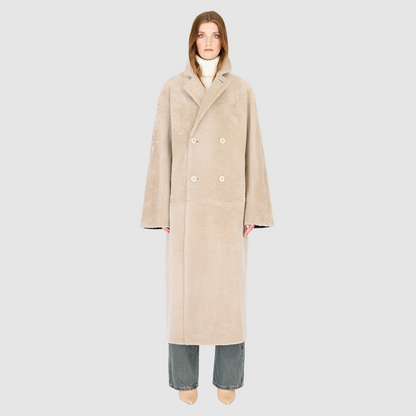 The DANIELLE Duster is a statement in heritage-inspired luxury and modern versatility. Crafted in black beige nappa and plush iron wool shearling, this reversible oversized coat transitions effortlessly from sleek leather to cozy teddy texture. Its elongated silhouette is enhanced with a slight drop shoulder, back vent, and double-breasted button closure, creating timeless elegance with functional edge. Practical single welt pockets on the suede side and slash pockets on the wool side