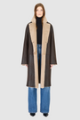 The ELLE Coat is a heritage-inspired oversized reversible shearling piece crafted in a oxen brown nappa ironed wool teddy. Designed to transition seamlessly from smooth suede to plush wool-out texture, this versatile style blends timeless tailoring with modern après-ski elegance. A slight drop shoulder, double-breasted button closure, and back vent add structure to its oversized silhouette. Functional single welt pockets on the suede side and slash pockets on the ironed wool side.