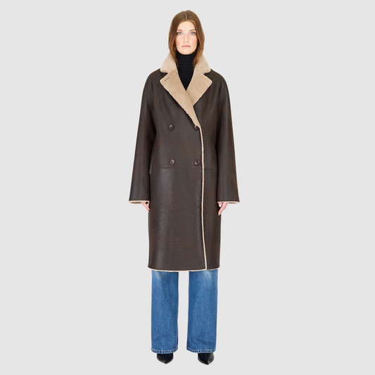 The ELLE Coat is a heritage-inspired oversized reversible shearling piece crafted in a oxen brown nappa ironed wool teddy. Designed to transition seamlessly from smooth suede to plush wool-out texture, this versatile style blends timeless tailoring with modern après-ski elegance. A slight drop shoulder, double-breasted button closure, and back vent add structure to its oversized silhouette. Functional single welt pockets on the suede side and slash pockets on the ironed wool side.