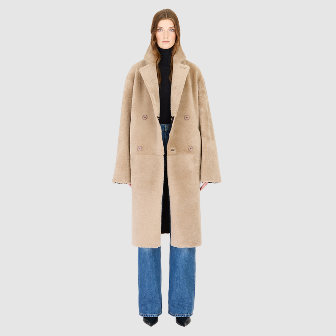 The ELLE Coat is a heritage-inspired oversized reversible shearling piece crafted in a oxen brown nappa ironed wool teddy. Designed to transition seamlessly from smooth suede to plush wool-out texture, this versatile style blends timeless tailoring with modern après-ski elegance. A slight drop shoulder, double-breasted button closure, and back vent add structure to its oversized silhouette. Functional single welt pockets on the suede side and slash pockets on the ironed wool side.