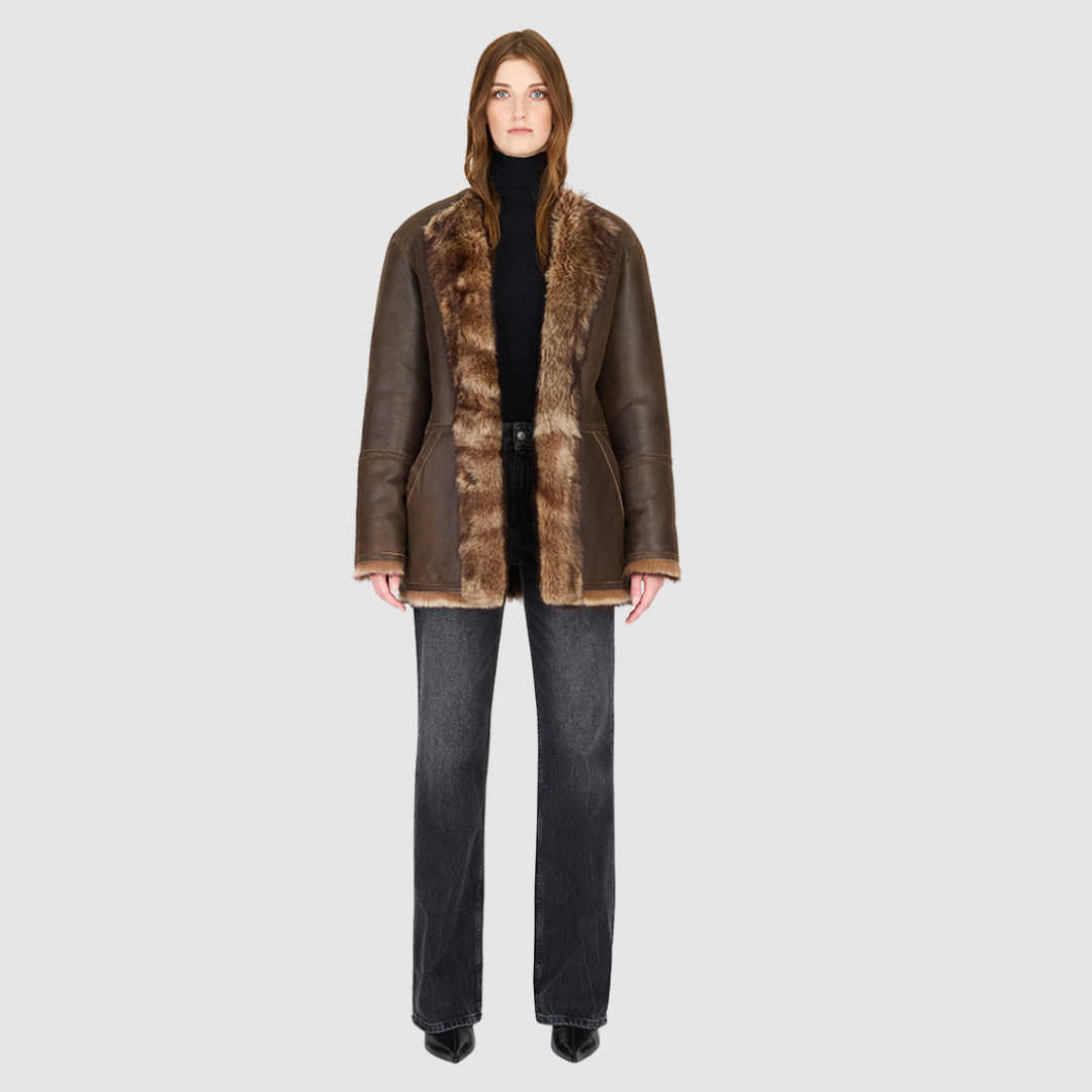 The Illumi Burma Nappa Toscana Jacket redefines modern luxury with its reversible, collarless design. Crafted from supple nappa leather and plush Toscana shearling, this oversized teddy-inspired silhouette offers two distinct looks in one. The wool-out side showcases rich texture and warmth, while the smooth nappa side delivers a sleek, refined finish. Designed for versatility and comfort, it features patch pockets on both sides and a clean snap-front closure—perfect for transitioning from city dressing to 