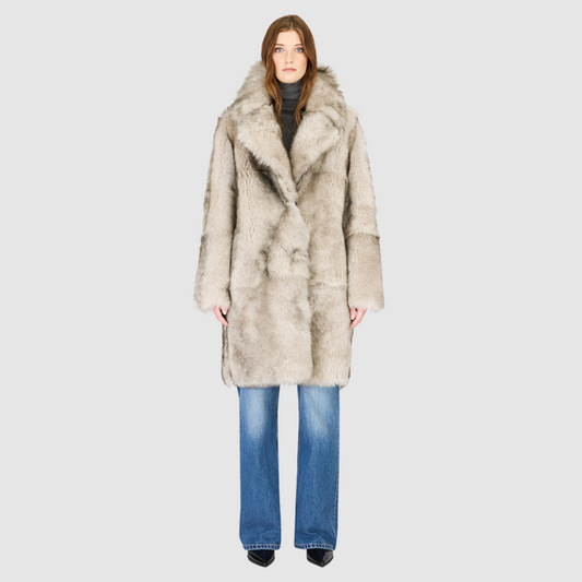 The JOY Jacket is a heritage-inspired reversible outerwear piece crafted in yingyang Toscana shearling. Designed to flip seamlessly from plush oversized teddy to sleek suede, it offers versatile styling for both après-ski sophistication and everyday winter elegance. With a drop shoulder, large notch collar, and oversized silhouette, JOY combines comfort with modern edge. Functional slash side pockets on the teddy side and single welt pockets on the nappa side, along with a front button closure.