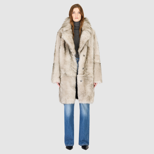 The JOY Jacket is a heritage-inspired reversible outerwear piece crafted in yingyang Toscana shearling. Designed to flip seamlessly from plush oversized teddy to sleek suede, it offers versatile styling for both après-ski sophistication and everyday winter elegance. With a drop shoulder, large notch collar, and oversized silhouette, JOY combines comfort with modern edge. Functional slash side pockets on the teddy side and single welt pockets on the nappa side, along with a front button closure.