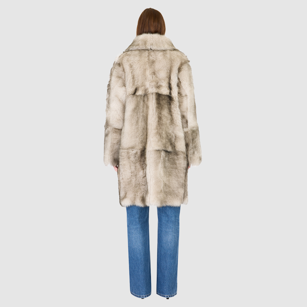 The JOY Jacket is a heritage-inspired reversible outerwear piece crafted in yingyang Toscana shearling. Designed to flip seamlessly from plush oversized teddy to sleek suede, it offers versatile styling for both après-ski sophistication and everyday winter elegance. With a drop shoulder, large notch collar, and oversized silhouette, JOY combines comfort with modern edge. Functional slash side pockets on the teddy side and single welt pockets on the nappa side, along with a front button closure.
