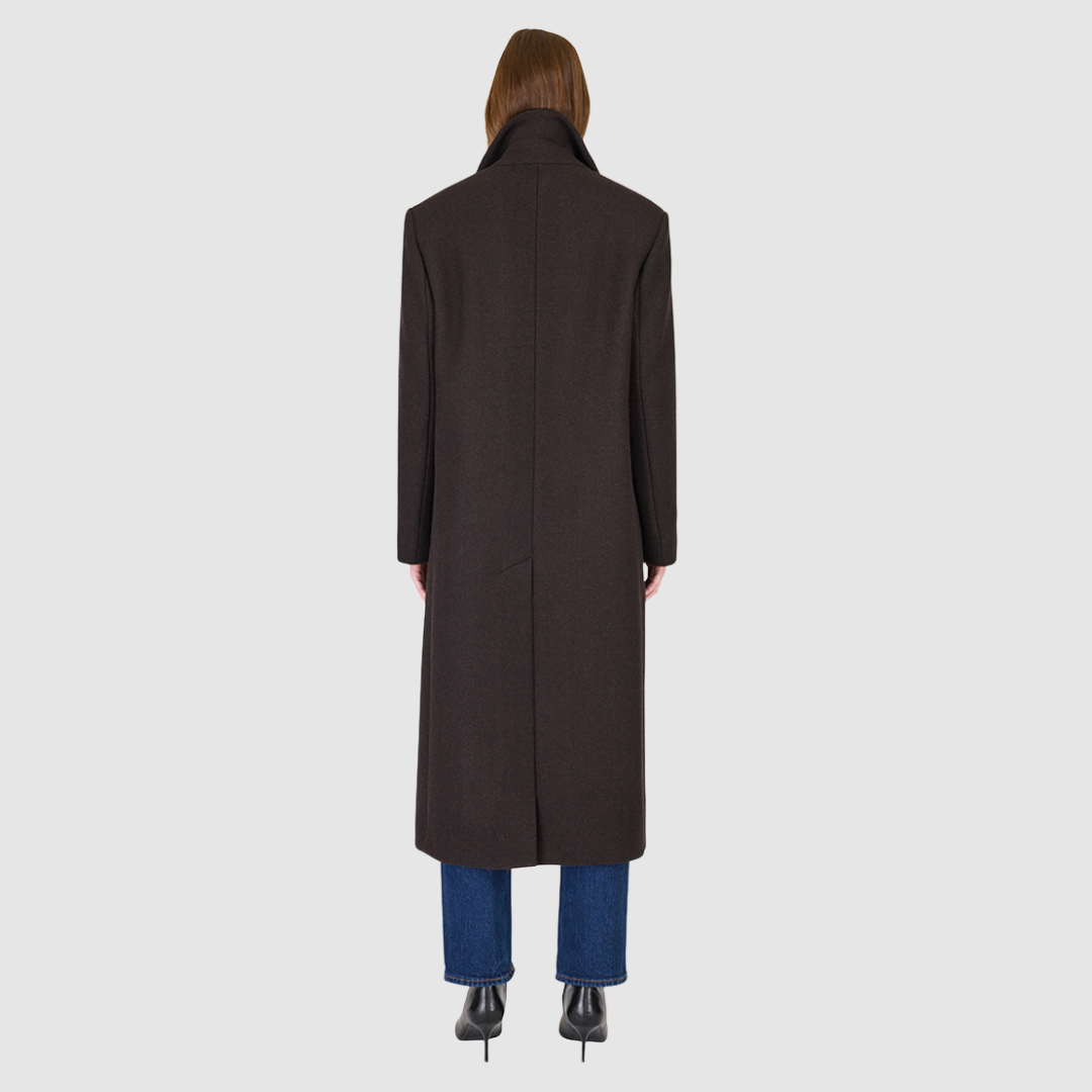 The KENNEDY Brown Herringbone Wool Coat delivers timeless tailoring in a superfine Italian wool blend. Its double-breasted silhouette is structured through the shoulders and arms with relaxed ease through the torso, creating a refined, modern fit. A classic spread collar and back vent enhance the polished silhouette, while subtle welt pockets add functional elegance. Designed for versatile wear, KENNEDY is a luxurious staple for any sophisticated outerwear collection.