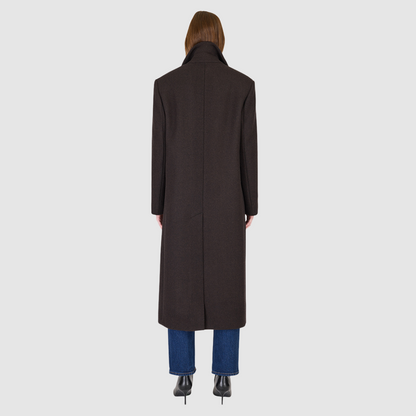 The KENNEDY Brown Herringbone Wool Coat delivers timeless tailoring in a superfine Italian wool blend. Its double-breasted silhouette is structured through the shoulders and arms with relaxed ease through the torso, creating a refined, modern fit. A classic spread collar and back vent enhance the polished silhouette, while subtle welt pockets add functional elegance. Designed for versatile wear, KENNEDY is a luxurious staple for any sophisticated outerwear collection.