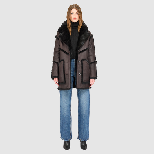 The LUREEN Coat is a luxury reversible semi-suede outerwear piece crafted in Java Toscana. Designed to flip seamlessly from smooth semi-suede to plush Toscana wool teddy, it offers versatile styling for cold-weather layering. The wool-out Toscana seam detailing on the semi-suede side, combined with a drop shoulder and relaxed fit through shoulders, arms, and torso, creates effortless volume and structure. An oversized Toscana notch collar, patch pockets on both sides, and a front button closure.