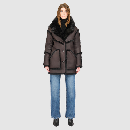 The LUREEN Coat is a luxury reversible semi-suede outerwear piece crafted in Java Toscana. Designed to flip seamlessly from smooth semi-suede to plush Toscana wool teddy, it offers versatile styling for cold-weather layering. The wool-out Toscana seam detailing on the semi-suede side, combined with a drop shoulder and relaxed fit through shoulders, arms, and torso, creates effortless volume and structure. An oversized Toscana notch collar, patch pockets on both sides, and a front button closure.