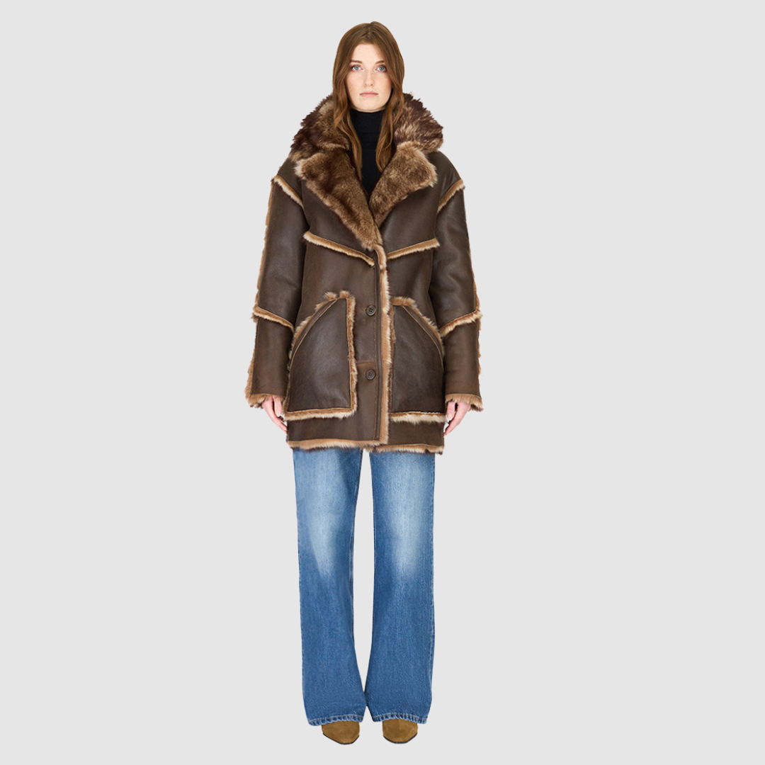 The LUREEN Coat is a luxury reversible semi-suede outerwear piece crafted in Burma Toscana. Designed to flip seamlessly from smooth semi-suede to plush Toscana wool teddy, it offers versatile styling for cold-weather layering. The wool-out Toscana seam detailing on the semi-suede side, combined with a drop shoulder and relaxed fit through shoulders, arms, and torso, creates effortless volume and structure. An oversized Toscana notch collar, patch pockets on both sides, and a front button closure complete th