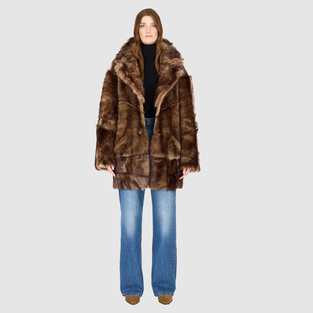 The LUREEN Coat is a luxury reversible semi-suede outerwear piece crafted in Burma Toscana. Designed to flip seamlessly from smooth semi-suede to plush Toscana wool teddy, it offers versatile styling for cold-weather layering. The wool-out Toscana seam detailing on the semi-suede side, combined with a drop shoulder and relaxed fit through shoulders, arms, and torso, creates effortless volume and structure. An oversized Toscana notch collar, patch pockets on both sides, and a front button closure complete th