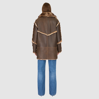 The LUREEN Coat is a luxury reversible semi-suede outerwear piece crafted in Burma Toscana. Designed to flip seamlessly from smooth semi-suede to plush Toscana wool teddy, it offers versatile styling for cold-weather layering. The wool-out Toscana seam detailing on the semi-suede side, combined with a drop shoulder and relaxed fit through shoulders, arms, and torso, creates effortless volume and structure. An oversized Toscana notch collar, patch pockets on both sides, and a front button closure complete th