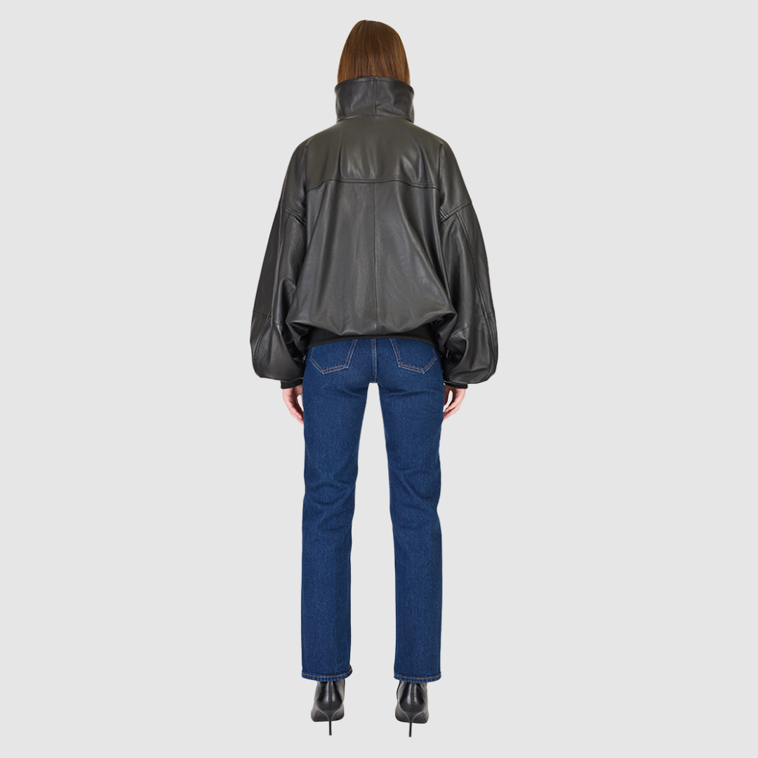 The Realm Black Leather Anorak Jacket is a modern interpretation of the classic anorak, elevated in luxury leather for a bold yet versatile statement. Designed with an oversized silhouette, it features a structured funnel neck collar and a concealed half-zip placket with gunmetal snap closures. Voluminous balloon sleeves and a cinched hem bring sculptural dimension, while functional flap pockets add everyday utility. A fusion of designer craftsmanship and contemporary outerwear design