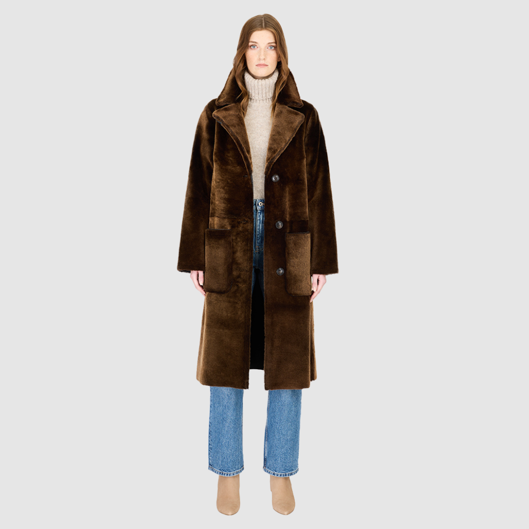 The ZIRA Coat is a heritage-inspired vintage reversible shearling jacket crafted in macassar nappa and iron wool. Designed to flip effortlessly from sleek nappa to plush iron wool teddy, it delivers versatile styling for both après-ski sophistication and everyday cold-weather elegance. Featuring a relaxed dropped shoulder, notch collar, and 3-button closure, ZIRA combines modern tailoring with timeless texture. Practical zip pockets on the nappa side and patch pockets on the teddy side, along with tie belt