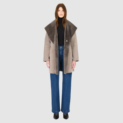 The BAYLIE Reversible Shearling Jacket is a statement in modern versatility and effortless luxury. Crafted in fog suede that reverses to plush ironed wool, it offers two distinct looks in one oversized silhouette. An oversized hood that converts to a dramatic shawl collar adds functional elegance, while raw-edge finishing underscores its contemporary appeal. Designed with drop shoulders and pull-through pockets, BAYLIE moves seamlessly between heritage inspiration and après-ski sophistication.