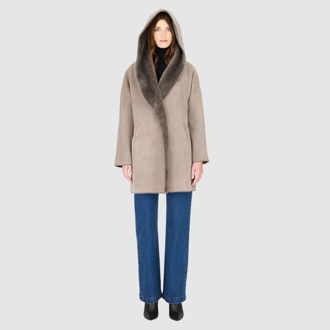 The BAYLIE Reversible Shearling Jacket is a statement in modern versatility and effortless luxury. Crafted in fog suede that reverses to plush ironed wool, it offers two distinct looks in one oversized silhouette. An oversized hood that converts to a dramatic shawl collar adds functional elegance, while raw-edge finishing underscores its contemporary appeal. Designed with drop shoulders and pull-through pockets, BAYLIE moves seamlessly between heritage inspiration and après-ski sophistication.