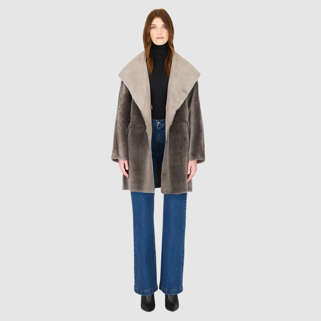 The BAYLIE Reversible Shearling Jacket is a statement in modern versatility and effortless luxury. Crafted in fog suede that reverses to plush ironed wool, it offers two distinct looks in one oversized silhouette. An oversized hood that converts to a dramatic shawl collar adds functional elegance, while raw-edge finishing underscores its contemporary appeal. Designed with drop shoulders and pull-through pockets, BAYLIE moves seamlessly between heritage inspiration and après-ski sophistication.