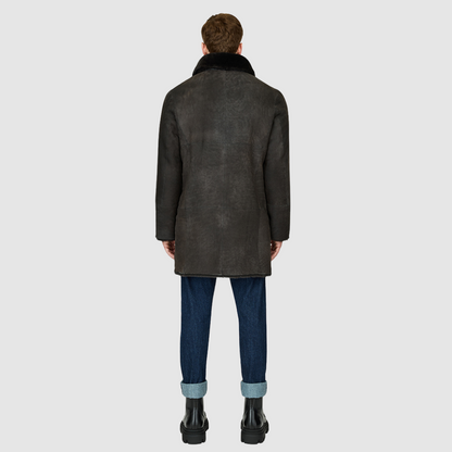 The Edson Black Vintage Reversible Shearling Jacket is a mid-length men’s coat engineered for winter warmth and versatile styling. Crafted from luxe suede with a plush ironed wool teddy reverse, it delivers two distinct silhouettes: structured and tailored when suede-out, or relaxed and oversized when wool-out. Designed with a spread collar, raw edge detailing, and functional dual pockets, this jacket provides effortless layering and superior cold-weather protection. Edson balances timeless shearling crafts