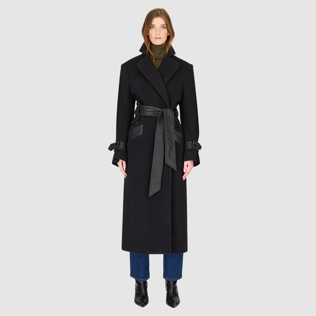 The EVERLY Black Wool Cashmere Blend Long Coat combines luxurious materials with structured, architectural design. Crafted from an Italian wool-cashmere blend, it features a leather tie belt at the waist to define the silhouette, along with structured shoulders and a classic notch collar. Leather cuff straps, a leather storm panel at the back, and single welt leather side pockets add refined detailing, while the back vent ensures ease of movement. 
