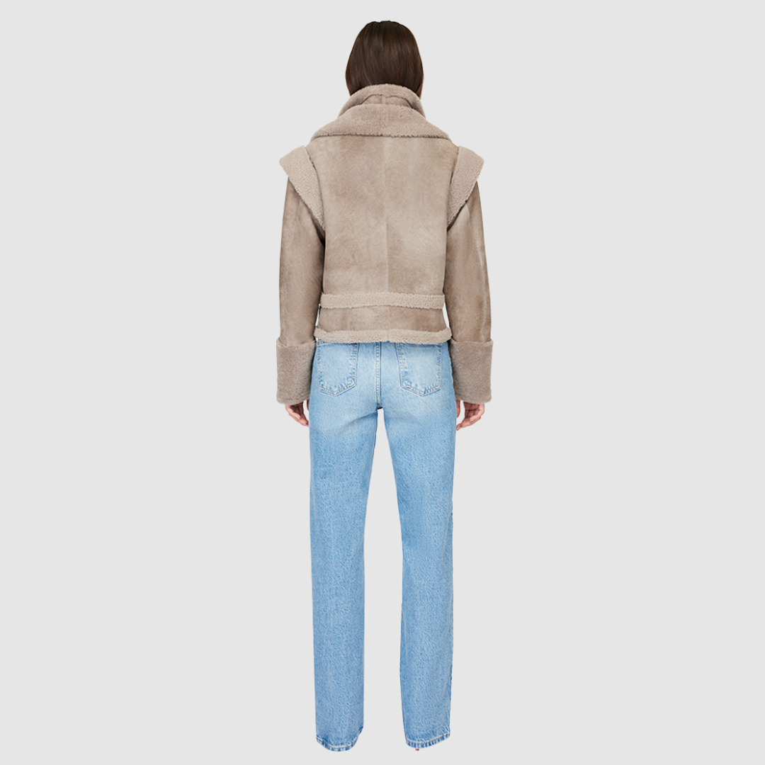 The GRAVITY Jacket is a heritage-inspired cropped shearling moto crafted in smoked quartz nappa leather with&nbsp;&nbsp;wool collar, shoulders, and trims for luxe texture. Its double curly wool collar and convertible design with removable zip sleeves allow it to transform into a vest, offering versatile layering for après-ski adventures or urban winter styling. Functional interior zip pocket, exterior single welt side pockets, and front zip with button closure complete this dynamic, modern shearling moto.