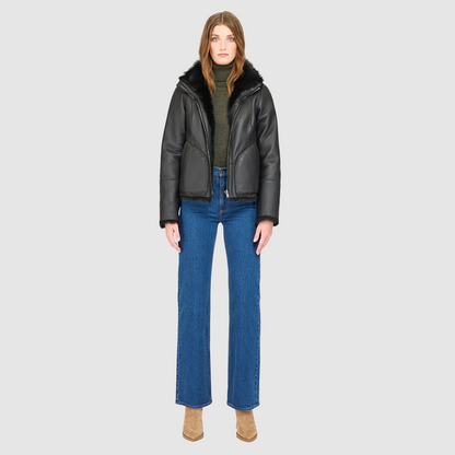 This cropped teddy jacket features a reversible design, with wool-out on one side and nappa-out on the other. The relaxed shoulder, spread collar, and slash side pockets provide comfort and functionality, while the front zip closure adds a practical touch.