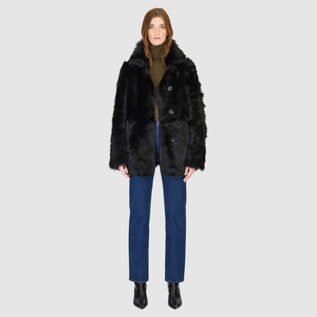 The MILKY WAY Jacket is a versatile statement piece crafted in Jet Toscana shearling, designed as a reversible teddy that flips to a nappa skin-out jacket. It offers a relaxed fit when worn wool-out and a regular fit when worn skin-out. A spread collar adds structure, while slash side pockets on the teddy side and patch side pockets on the nappa side provide functionality. Finished with a front button closure, MILKY WAY combines plush texture with sleek nappa styling for modern cold-weather versatility.