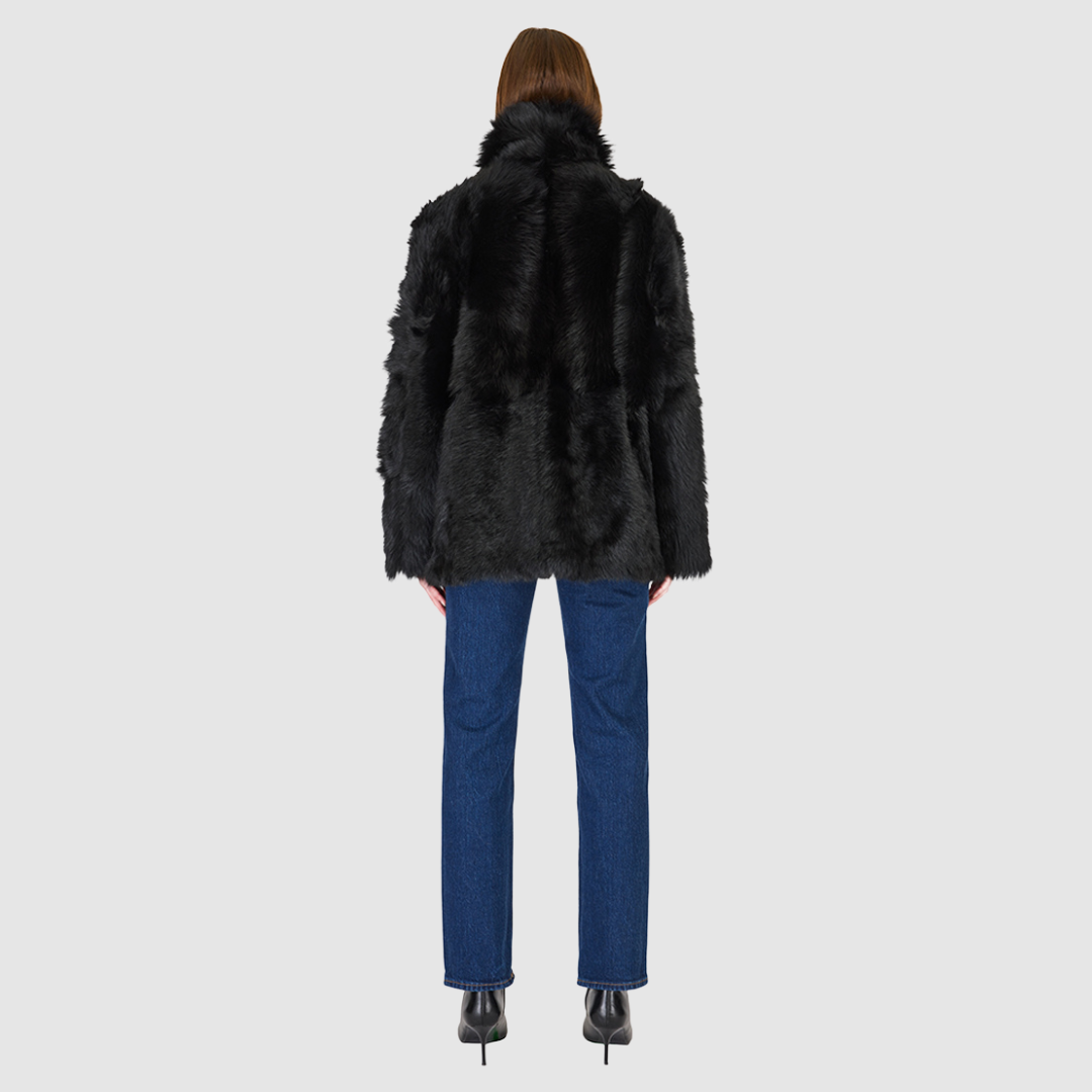 The MILKY WAY Jacket is a versatile statement piece crafted in Jet Toscana shearling, designed as a reversible teddy that flips to a nappa skin-out jacket. It offers a relaxed fit when worn wool-out and a regular fit when worn skin-out. A spread collar adds structure, while slash side pockets on the teddy side and patch side pockets on the nappa side provide functionality. Finished with a front button closure, MILKY WAY combines plush texture with sleek nappa styling for modern cold-weather versatility.