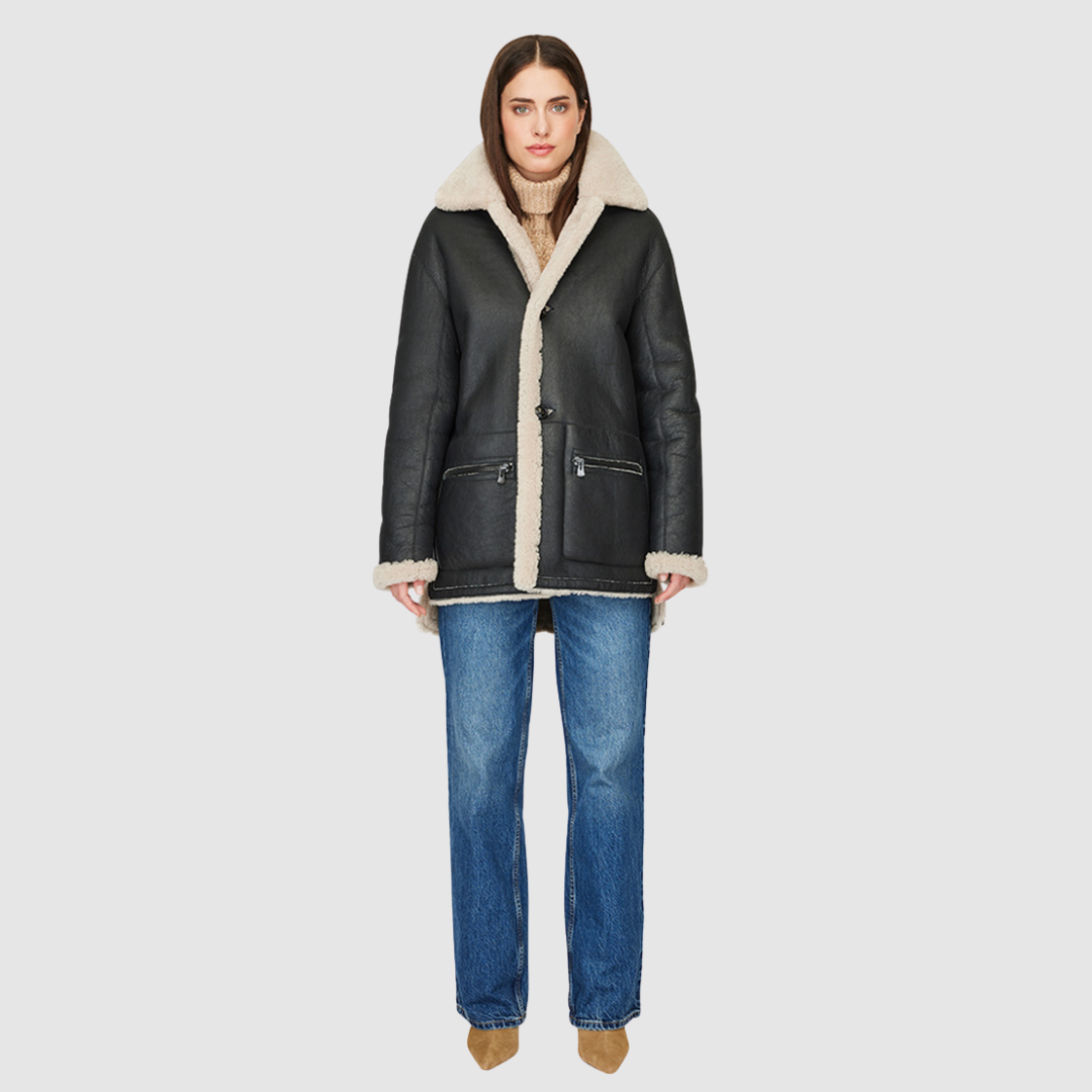 The SACHS Reversible Shearling Shacket redefines cold-weather layering with a modern, oversized silhouette and versatile design. Crafted in supple black nappa shearling that reverses to a beige curly wool teddy, it offers two distinct looks in one. Details like the drop shoulder, high-low hemline, and structured notch collar add polish while maintaining a relaxed attitude. Perfect for everyday wear or après-ski styling, SACHS balances heritage shearling craftsmanship with contemporary ease.