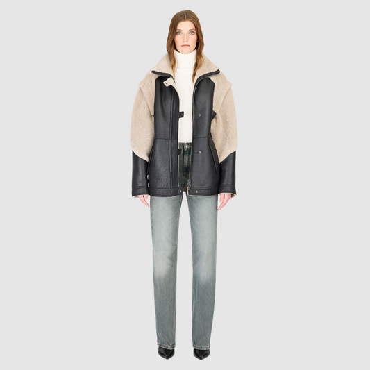 The SOLO Black Beige Moto Jacket redefines versatility with a bold mixed-media design that fuses supple nappa leather and plush curly wool shearling. Designed with a relaxed fit through the shoulders, arms, and torso, this statement jacket easily converts into a vest with removable zip sleeves for year-round styling. The curly wool collar, shoulders, and sleeves bring rich texture, while the stand collar and moto-inspired hardware emphasize its urban edge. 