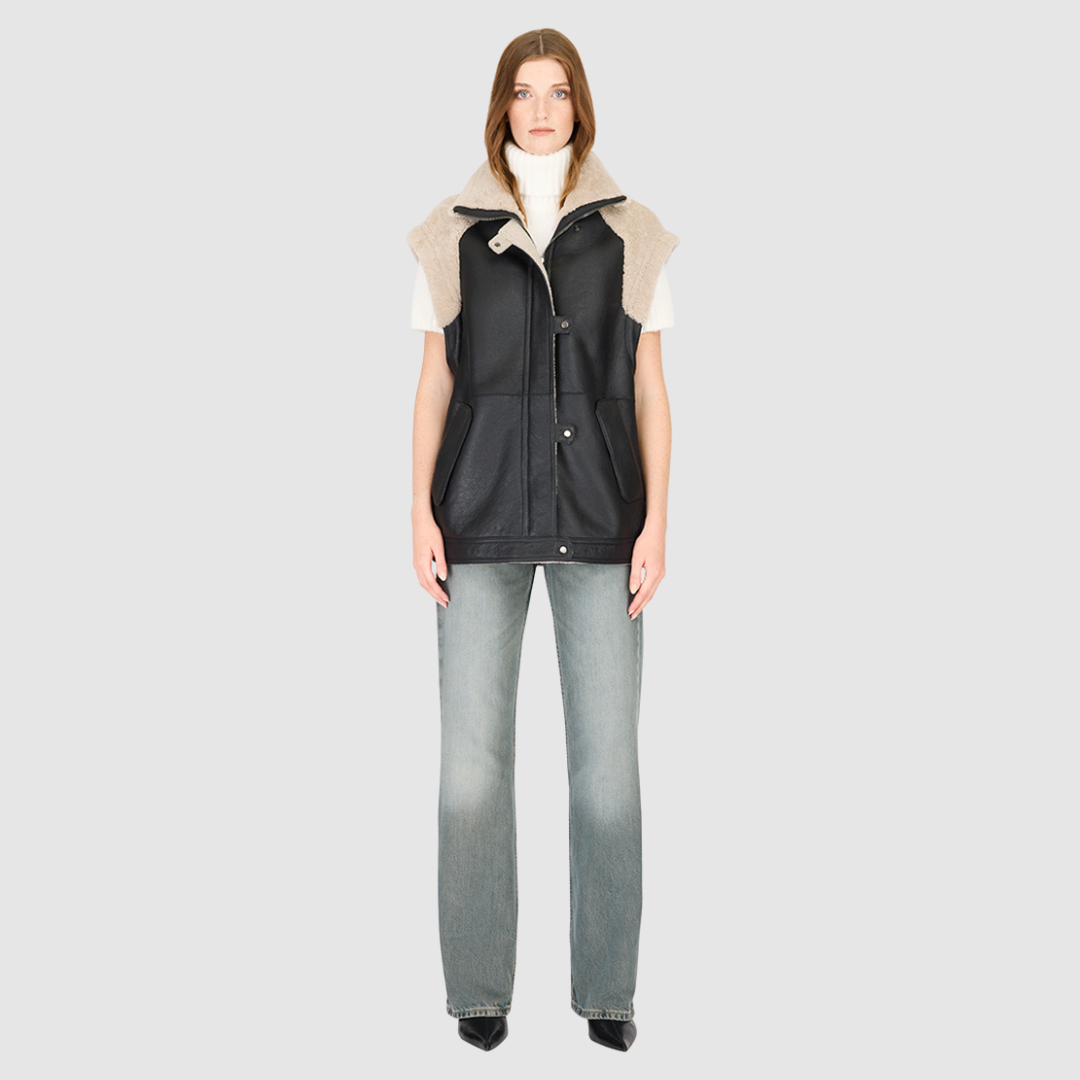 The SOLO Black Beige Moto Jacket redefines versatility with a bold mixed-media design that fuses supple nappa leather and plush curly wool shearling. Designed with a relaxed fit through the shoulders, arms, and torso, this statement jacket easily converts into a vest with removable zip sleeves for year-round styling. The curly wool collar, shoulders, and sleeves bring rich texture, while the stand collar and moto-inspired hardware emphasize its urban edge. 