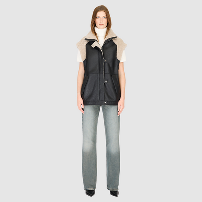 The SOLO Black Beige Moto Jacket redefines versatility with a bold mixed-media design that fuses supple nappa leather and plush curly wool shearling. Designed with a relaxed fit through the shoulders, arms, and torso, this statement jacket easily converts into a vest with removable zip sleeves for year-round styling. The curly wool collar, shoulders, and sleeves bring rich texture, while the stand collar and moto-inspired hardware emphasize its urban edge. 