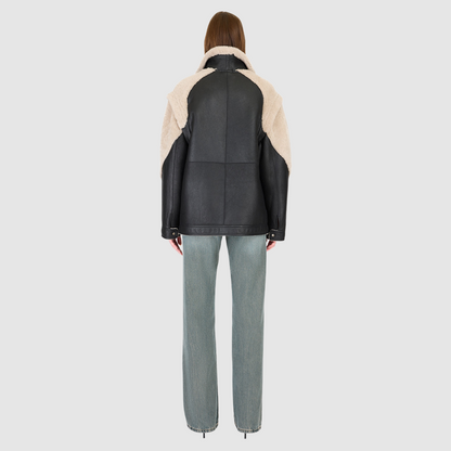 The SOLO Black Beige Moto Jacket redefines versatility with a bold mixed-media design that fuses supple nappa leather and plush curly wool shearling. Designed with a relaxed fit through the shoulders, arms, and torso, this statement jacket easily converts into a vest with removable zip sleeves for year-round styling. The curly wool collar, shoulders, and sleeves bring rich texture, while the stand collar and moto-inspired hardware emphasize its urban edge. 