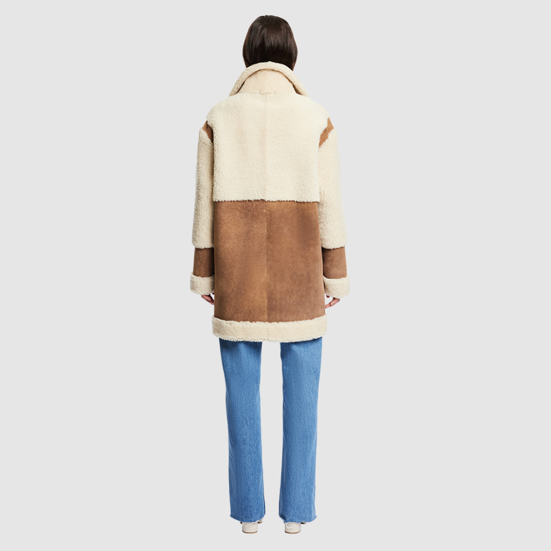 The URBAN Reversible Shearling Jacket fuses contemporary design with timeless shearling craftsmanship. Cut in an oversized silhouette with relaxed shoulders, deep armholes, and wide sleeves, it offers effortless comfort with a modern edge. Crafted from sleek cashew suede and plush beige curly wool, its fully reversible construction allows for versatile styling. With its straight fit and clean snap closure, URBAN is a bold statement piece ideal for both heritage looks and après-ski layering.