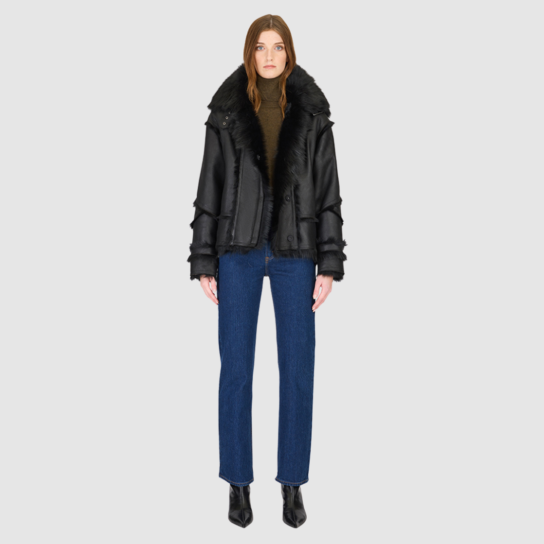 The VENUS Moto Shearling Jacket is a modern interpretation of the classic moto, crafted in supple nappa leather with Toscana wool-out seam detailing. Its drop-shoulder silhouette adds effortless ease, while the spread Toscana collar with buckle detail delivers a bold, statement finish. Designed for both form and function, VENUS features interior and exterior zip pockets to secure essentials. A front snap closure completes this sleek, cold-weather essential with understated edge.