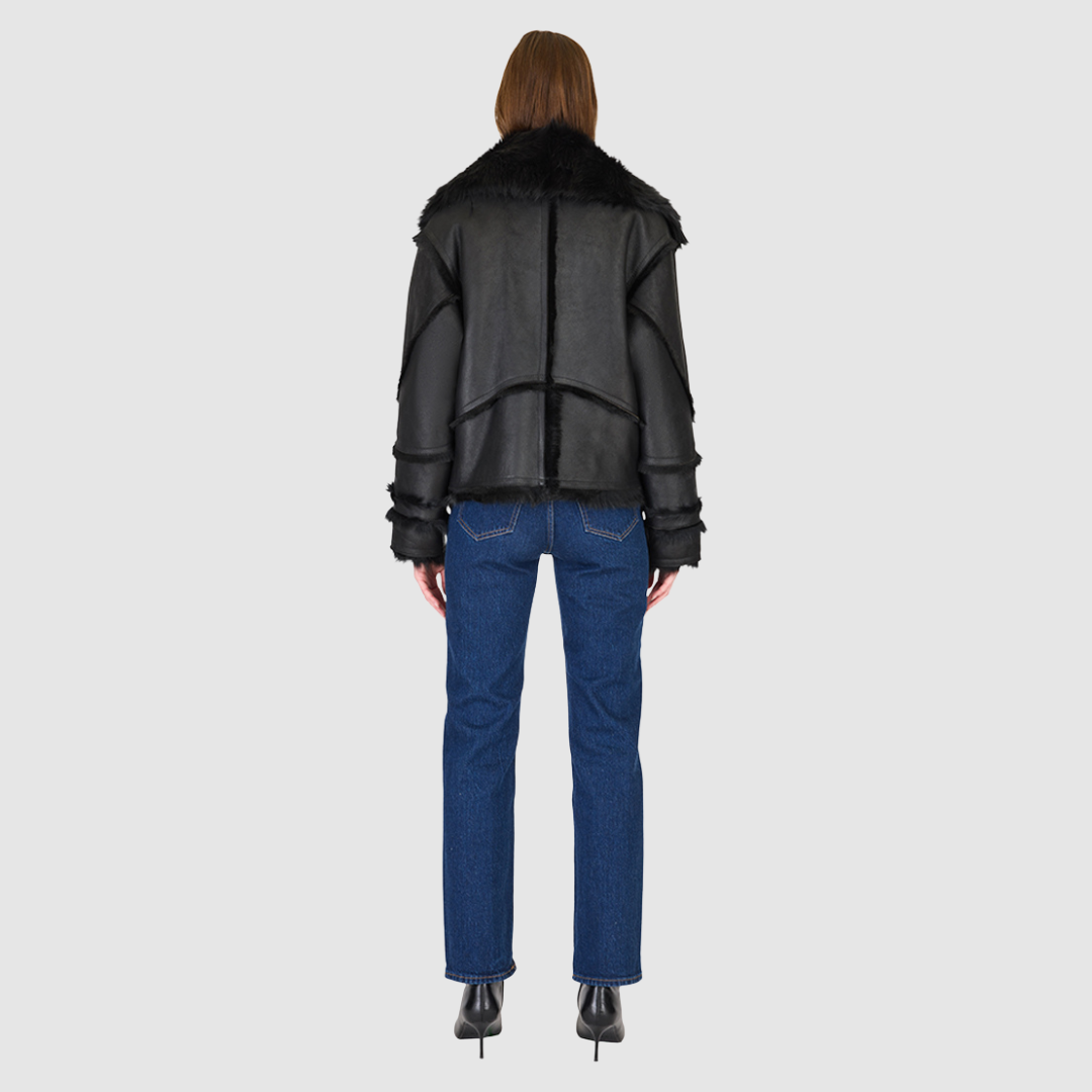 The VENUS Moto Shearling Jacket is a modern interpretation of the classic moto, crafted in supple nappa leather with Toscana wool-out seam detailing. Its drop-shoulder silhouette adds effortless ease, while the spread Toscana collar with buckle detail delivers a bold, statement finish. Designed for both form and function, VENUS features interior and exterior zip pockets to secure essentials. A front snap closure completes this sleek, cold-weather essential with understated edge.