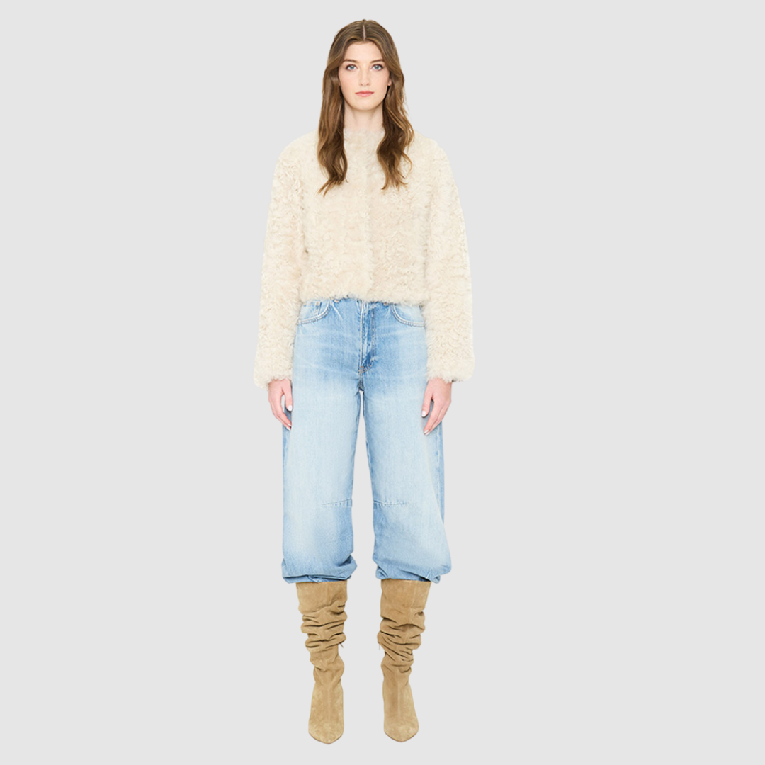 The HiSO SORA Jacket is a heritage-inspired cropped shearling jacket, masterfully crafted from premium curly wool shearling for rich texture and dimension. Its regular shoulder and tailored cropped silhouette create a sleek, contemporary fit, while the collarless design and clean edges offer a minimalist, modern aesthetic. Fully lined for exceptional comfort and designed with a hidden hook closure for a seamless finish, the jacket features standard straight sleeves and functional slash side pockets