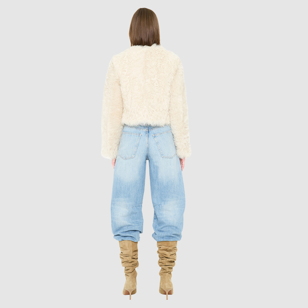 The HiSO SORA Jacket is a heritage-inspired cropped shearling jacket, masterfully crafted from premium curly wool shearling for rich texture and dimension. Its regular shoulder and tailored cropped silhouette create a sleek, contemporary fit, while the collarless design and clean edges offer a minimalist, modern aesthetic. Fully lined for exceptional comfort and designed with a hidden hook closure for a seamless finish, the jacket features standard straight sleeves and functional slash side pockets