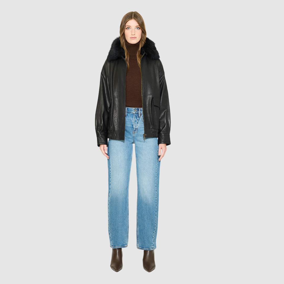 The TATE Bomber Jacket is a modern silhouette crafted in premium textured black leather. Designed with drop shoulders and a relaxed fit through the body, it delivers architectural volume and an easy, fluid drape. A dramatic, plush shearling collar and concealed front zip closure give it a clean, minimalist finish, while flap patch pockets and a gathered elasticized leather hem define the silhouette. Fully lined for comfort, TATE serves as a definitive statement piece for elevated cold-weather layering.