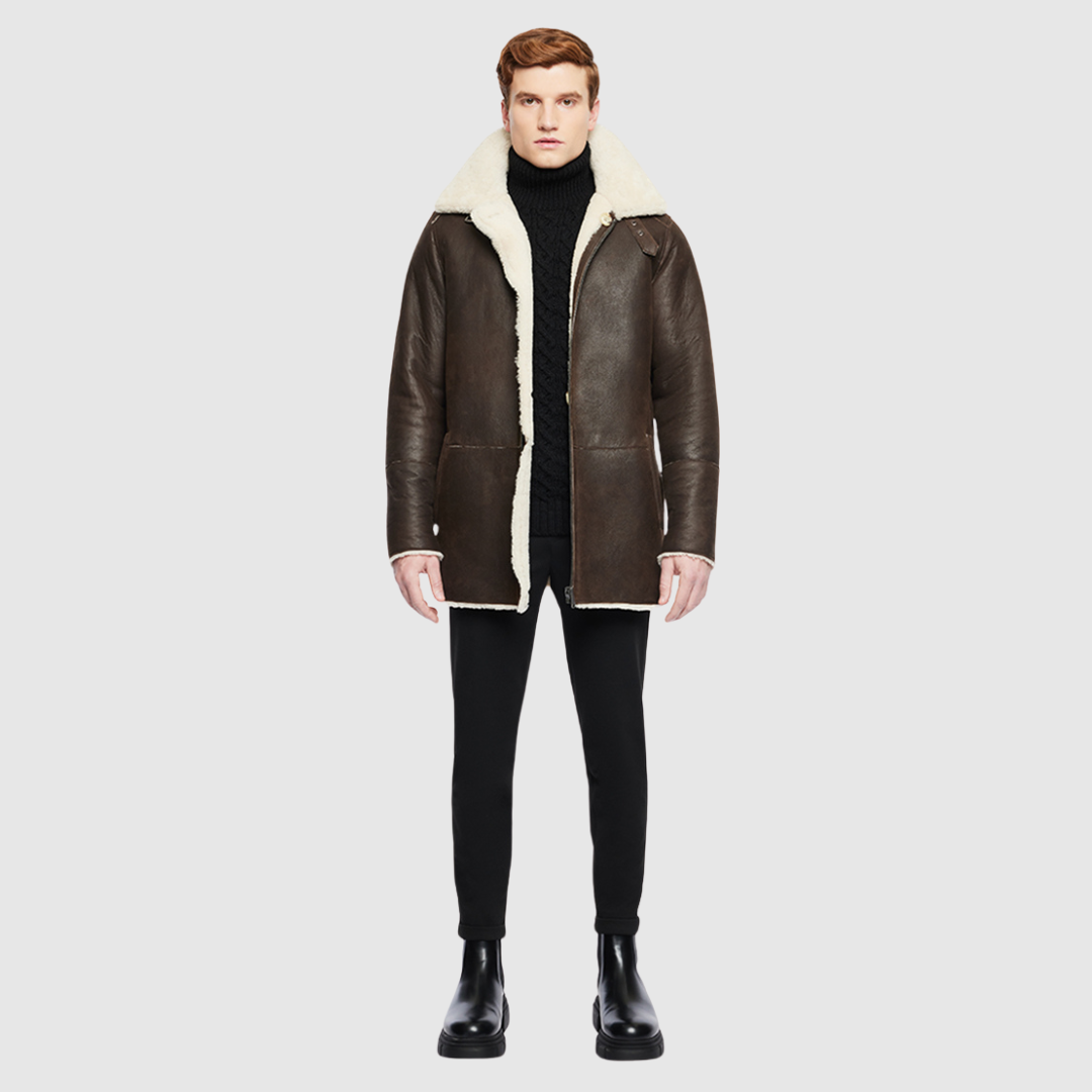 The Victor Arabica Reversible Shearling Jacket offers versatile styling with a luxurious nappa leather exterior that reverses to a plush curly wool teddy. Designed with a slight drop shoulder and a slim fit through the chest, it features a spread collar with buckle detailing for a contemporary edge. Functional pockets on both sides and a front zip with button closure combine utility with a refined, tailored silhouette.