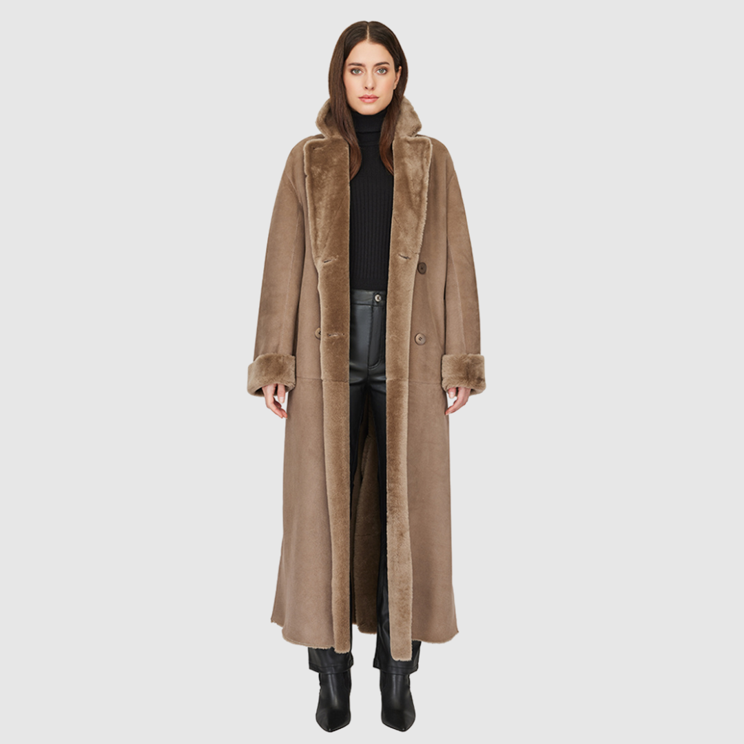 The DANIELLE Duster is a statement in heritage-inspired luxury and modern versatility. Crafted in taupe iron wool and plush iron wool shearling, this reversible oversized coat transitions effortlessly from sleek suede to cozy teddy texture. Its elongated silhouette is enhanced with a slight drop shoulder, back vent, and double-breasted button closure, creating timeless elegance with functional edge. Practical single welt pockets on the suede side and slash pockets on the wool side make DANIELLE a refined ch