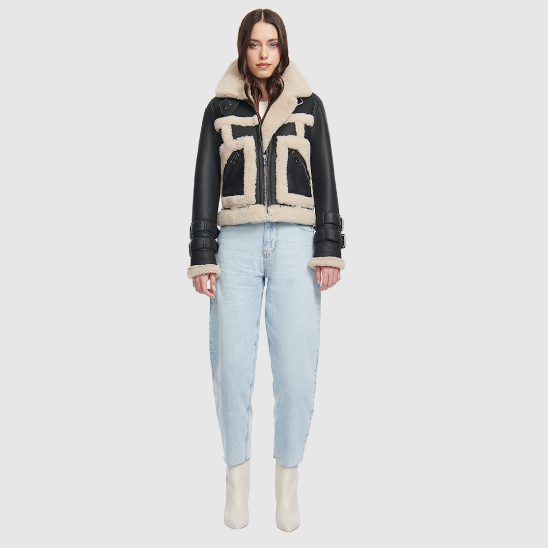 This cropped biker jacket is updated with contrasting wool seams. Crafted in genuine shearling, the jacket is finished with zip pockets and buckle accents at the collar and cuffs. Genuine Shearling Spread collar Long-sleeve Zipper closure Imported