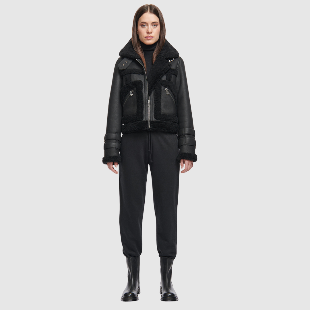 This cropped biker jacket is updated with contrasting wool seams. Crafted in genuine shearling, the jacket is finished with zip pockets and buckle accents at the collar and cuffs. Genuine Shearling Spread collar Long-sleeve Zipper closure Imported